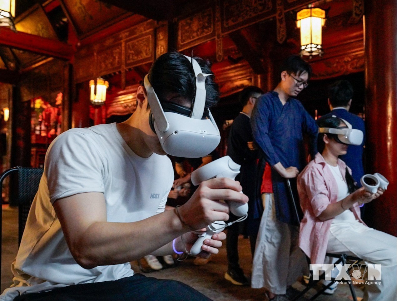 Du khách trải nghiệm công nghệ thực tế ảo tại tour đêm Văn Miếu. (Ảnh: Khánh Hoà/TTXVN)
